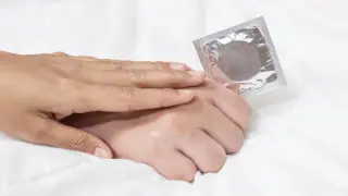Una pareja muestra un preservativo